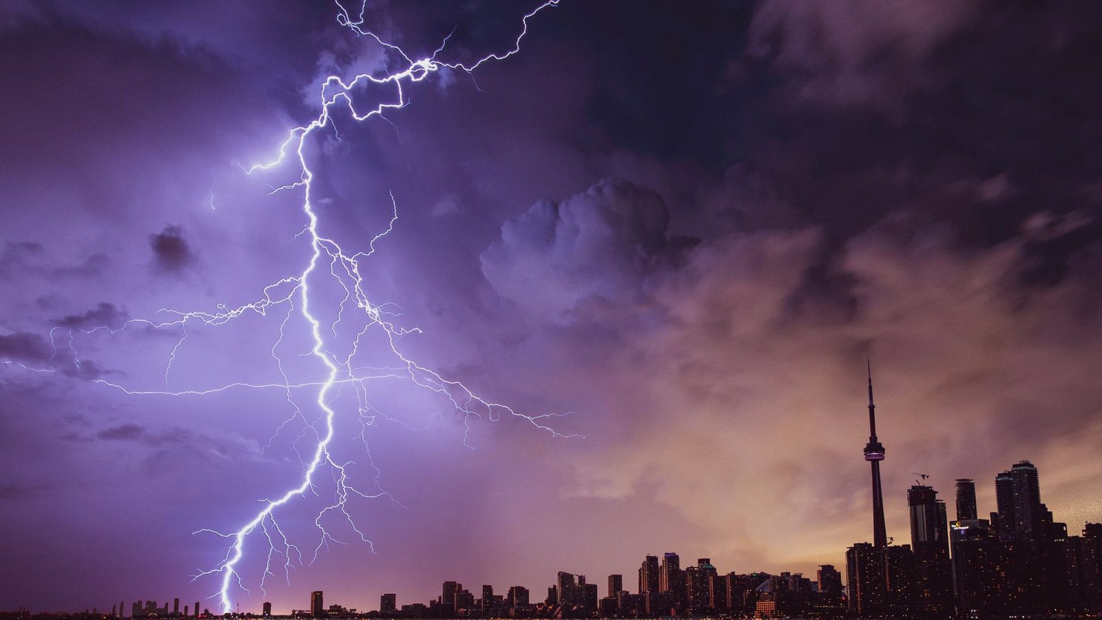 Lightning striking over a city skyline at night